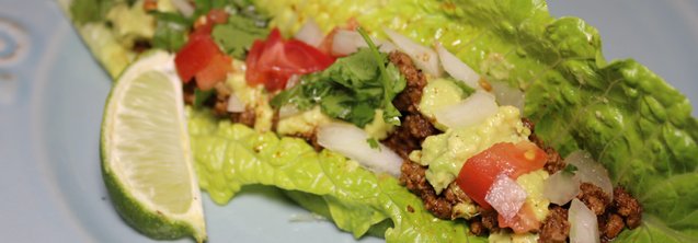 A romaine lettuce leaf stuffed with ground beef, guacamole, and a blend of tomatoes, onions and cilantro