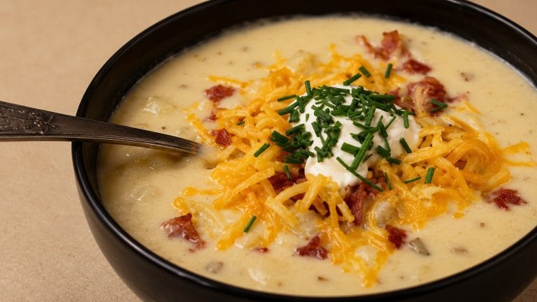 Creamy Outback Steakhouse potato soup recipe topped with melted cheese, crispy bacon, sour cream, and fresh chives